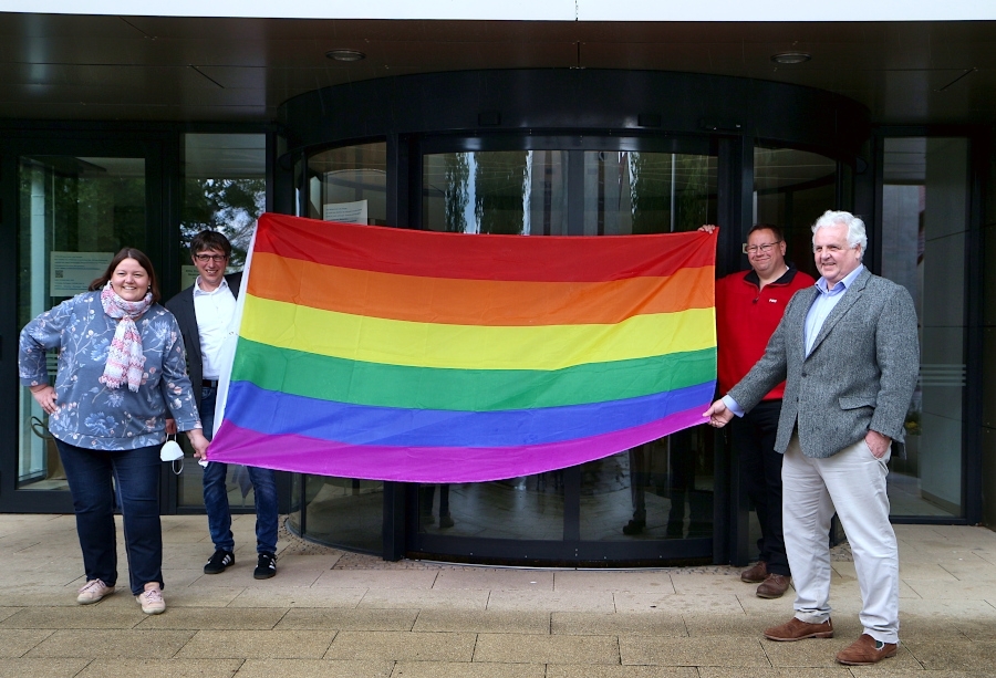 Christiane Frevert (Grüne), Bürgermeister Martin Hoffmann sowie die Fraktionsvorsitzenden Thomas Jahn (SPD) und Hermann Graf von der Schulenburg (FDP) halten die Regenbogenfahne. Sie wollen so ein Zeichen gegen den Hass gegen sexuell nicht hetero orientierte Menschen setzen. Foto: Thomas Dohna 