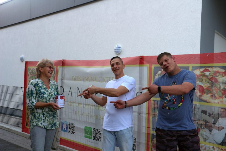 Doris Eversmeier hat die mit 1.000 Euro gefüllte Spendendose aus den Händen Daniele Venturas (Mitte) entgegengenommen. Dessen Nachbar und Freund Julian Stoll half bei der Eröffnung von Danieles Pizzeria am Samstag. Foto: Thomas Dohna