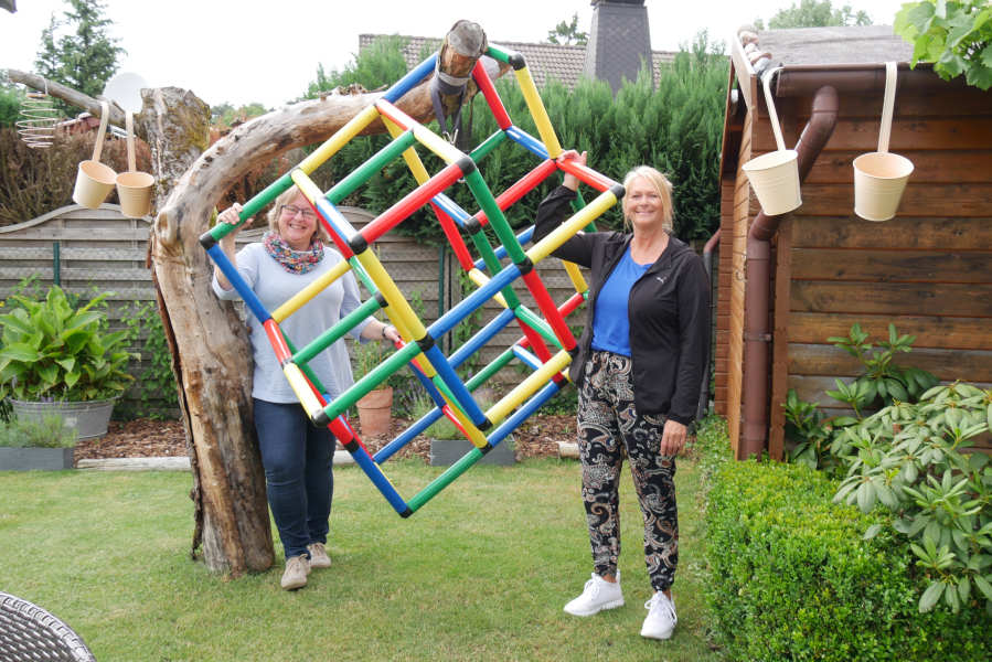 Fürs Foto am Baum: bevor die Kinder kommen, wird das Klettergerüst natürlich wieder auf den Rasen gestellt. Dagmar Freitag (rechts) und Antje Höper packen es gemeinsam an.