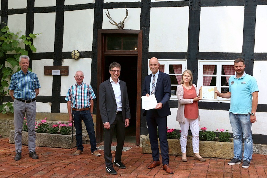 Klaus Sunkovsky (von links), zweiter Vorsitzender des Heimatvereins, Helmut Depping, Vorsitzender des Heimatvereins, Bürgermeister Martin Hoffmann Abteilungsdirektor Heimat der Bezirksregierung Jens Kronshage, Leader-Regionalmanagerin Susanne Weißhaupt und Sachbearbeiter Mathias Hartig freuen sich über das bewilligte Leaderprojekt Heimathof. Kronshage hält der Förderbescheid, Weißhaupt und Hartig die Plakette für das Leaderprojekt. Foto: Thomas Dohna