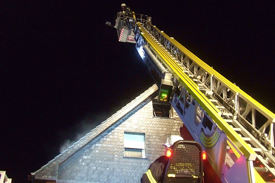 Im Korb der Drehleiter steht eine Einsatzkraft, um unter Atemschutz den Dachstuhlbrand zu löschen. Foto: Freiwillige Feuerwehr Leopoldshöhe