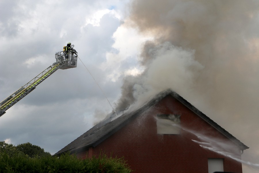 Von der Drehleiter und rechts vom Boden aus gibt die Feuerwehr Wasser auf das Dach. Foto: Edeltraud Dombert