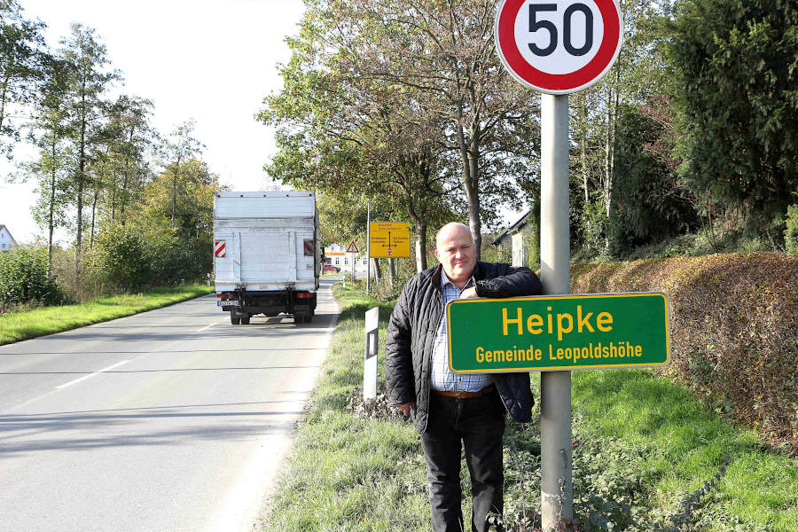 Andreas Brinkmann steht an der Ortshinweistafel für Heipke an der Schackenburger Straße. Gerade ist einer der vielen Lkw durchgefahren, die diese Straße täglich benutzen. Archivfoto: Thomas Dohna