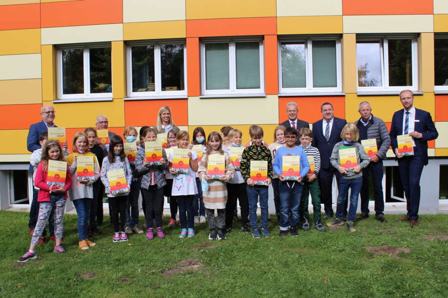 Über die neue Auflage des Heimatkundebuchs freuen sich: Michael Gerd Schnittger (Schulleiter der Grundschule Heiligenkirchen und Vorsitzender der Fachstelle Schule des Lippischen Heimatbundes), Wilfried Starke (Vorsitzender der Fachstelle Schule des Lippischen Heimatbundes), Ramona Stephan-Dzeko (Klassenlehrerin Grundschule Heiligenkirchen), Bernd Dabrock (Vorsitzender des Vorstandes der Sparkasse Lemgo), Landrat Dr. Axel Lehmann, Dr. Albert Hüser (Vorsitzender des Lippischen Heimatbundes), und Torsten Kahre (Bereichsleiter Privatkunden Sparkasse Paderborn-Detmold) mit der Klasse 4b (von links). Foto: Kreis Lippe.