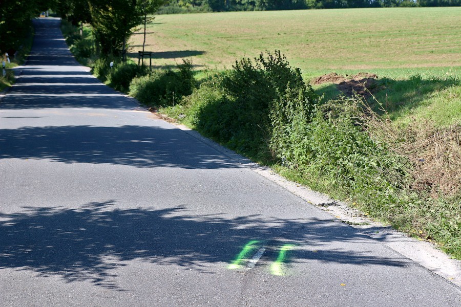 Die Markierung zeigt, wo das Unfallauto den Asphalt auf der Dorfstraße aufgekratzt hat. In Fortsetzung der Markierung ist die Böschung aufgewühlt. Dort ist das Fahrzeug aufgetroffen, bevor es wieder auf die Straße  gerutscht ist. Foto: Thomas Dohna