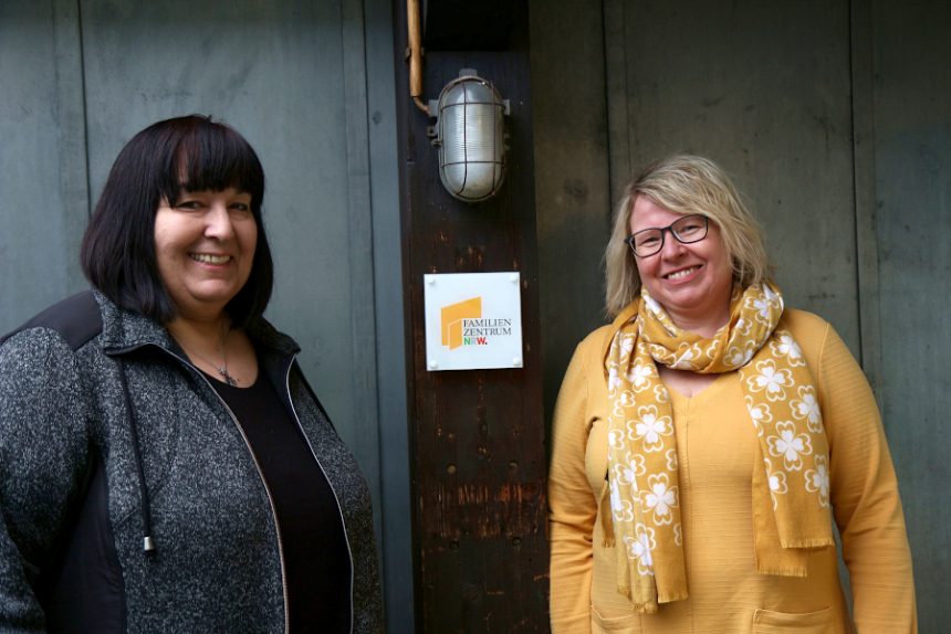 Claudia Märzke (links) und Petra Schwier stehen an der kleinen, etwas versteckt am Gebäude des Leos hängenden Plakette "Familienzentrum NRW". Foto: Thomas Dohna