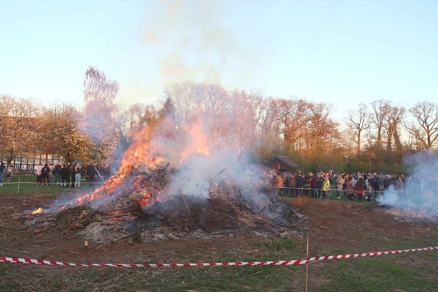 Hell loderm die Flammen aus dem Osterfeuerhaufen. Auf der Wiese des Heimathofes haben sich hunderte Menschen zusammengefunden. Foto: Thomas Dohna