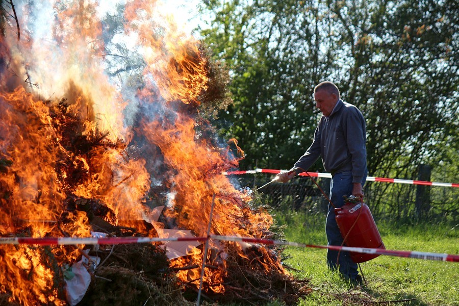 August Steinhage entzündet mit Hilfe eines Gasbrenners das Osterfeuer auf dem Heimathof. Als 2019 das Bild entstand, meinte er, es sei wohl das letzte Mal. Er ließ sich überzeugen, auch 2022 das Feuer zu entfachen. Foto: Thomas Dohna