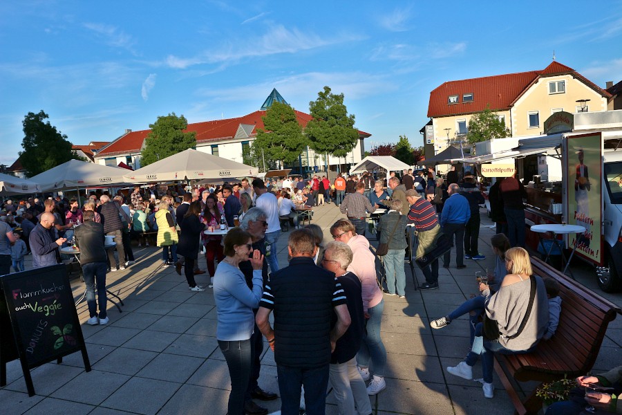 In Gruppen stehen die Menschen an Tischen zusammen. Foto: Thomas Dohna