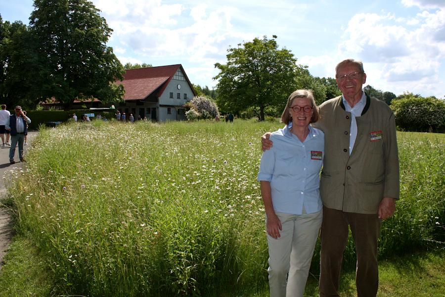 Marie-Luise und Hans-Jochen Asemissen öffneten den Garten des Bolhofes für die Allgemeinheit. Sie stehen vor einer Magerfläche, auf der massenhaft Blumen blühen. Foto: Thomas Dohna