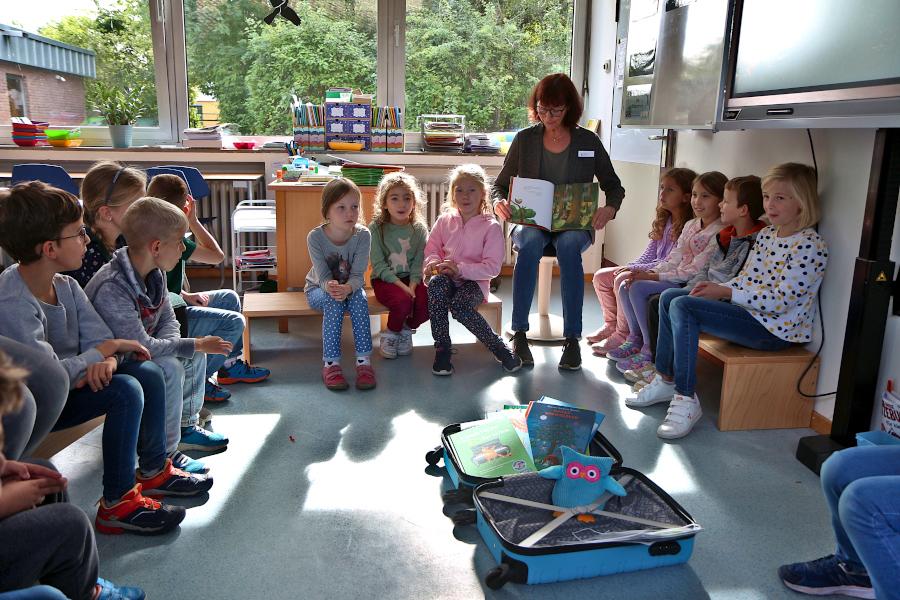 Beate Becker vom Kommunalen Integrationszentrum liest aus einem der Bücher aus dem Bücherkoffer (von) vor. Foto: Thomas Dohna