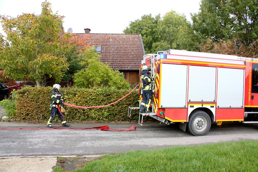 Vom LF10 herab werden sogenannte B-Schläuche verlegt. Sie sind aneinander gekuppelt. Die Feuerwehrleute stehen auf den Trittbrettern und ziehen während der Fahrt die Schäuche aus den Lagerkästen. Foto: Thomas Dohna