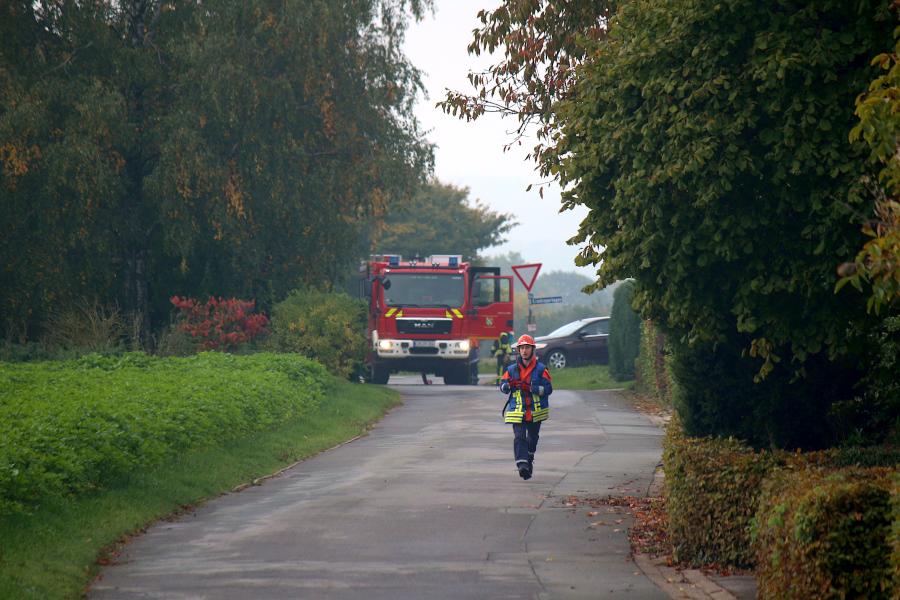 Das LF10 ist an der Einmündung zur Hakenheide stehengeblieben. Dort gibt es einen Hydranten. Das Fahrzeug ist für den Bau von Wasserversorgungen über lange Strecken ausgerüstet. Der Gruppenführer läuft zur Brandstelle. Foto: Thomas Dohna