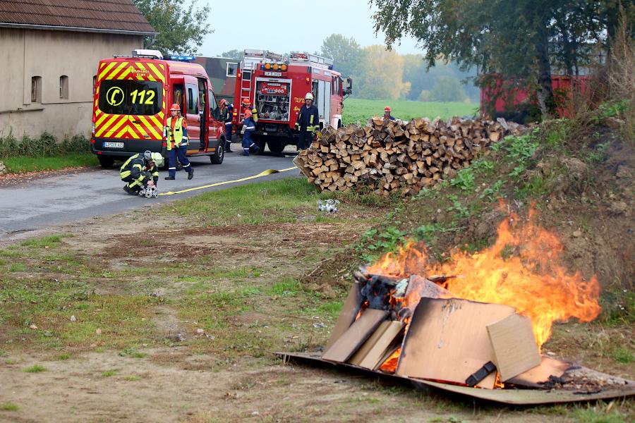 Den Brand haben die Betreuer für die Jugendfeuerwehr entfacht. Gerade wird eine Löschwasserversorgung aufgebaut. Foto: Thomas Dohna