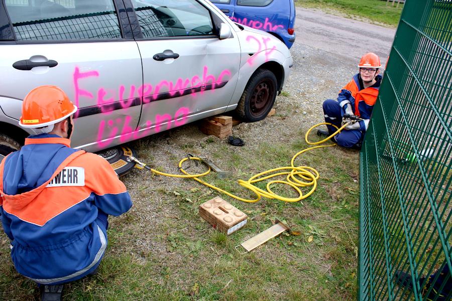 Mit Hilfe eines Hebekissens haben die Jugendfeuerwehrleute das Auto angehoben. Die Holzklötze stützen es zur Sicherheit ab. Foto: Thomas Dohna