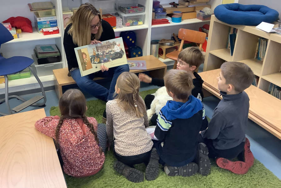 Lehrerin Manuela Knoche liest am Vorlesetag mit einer kleinen Gruppe Kindern aus einem Bilderbuch. Foto: Privat