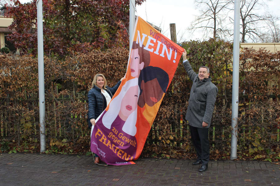 Nicole Krüger (Gleichstellungsbeauftragte Kreis Lippe) und Landrat Dr. Axel Lehmann hissen die orangene Fahne vor dem Kreishaus. Foto: Kreis Lippe