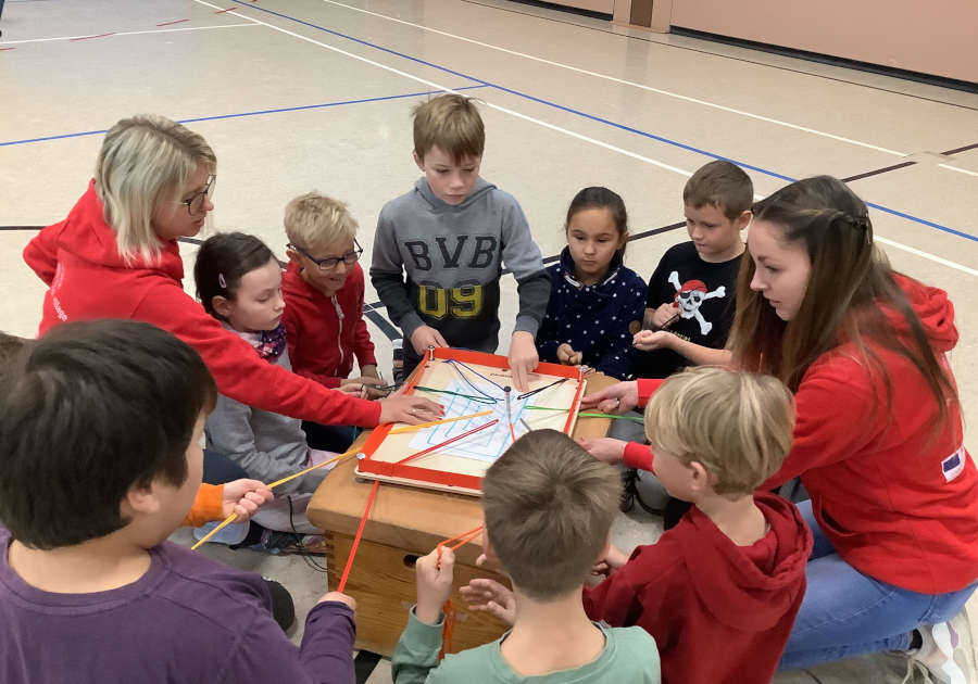 Sina Harst (links) und Delia Riedel vom Kreis Lippe erklären den Schülern beim Teambuilding-Tag der Grundschule Asemissen, wie man gemeinsam ans Ziel kommt. (Foto: Kreis Lippe)