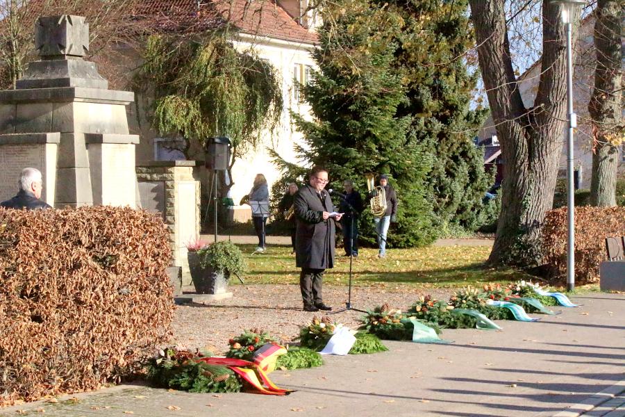 Pfarrer Hendrik Meier hält die Rede zum Totengedenken. Vor ihm liegen die Kräze, die am Ehrenmal abgelegt werden. Foto: Thomas Dohna