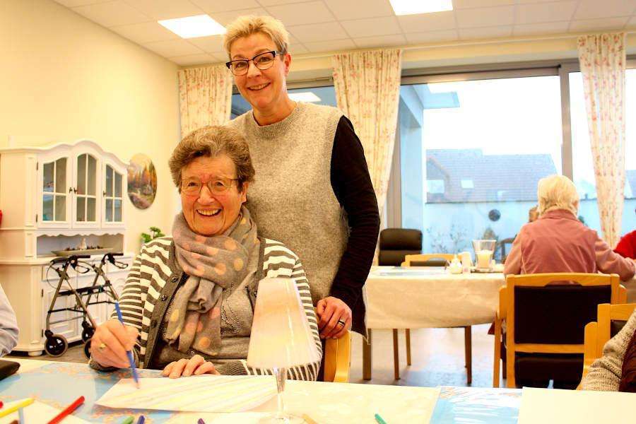 Yvonne Hoppe, Leiterin der Tagespflege Asemissen, steht hinter einer ihre Besucherinnen in der Tagespflege. Die Dame wollte ihren Namen nicht nennen, hatte beim Fotografieren aber viel Spaß. Foto: Thomas Dohna