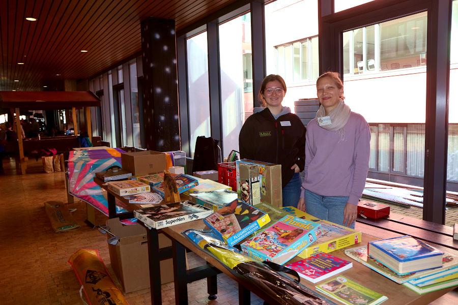 Ida Glatthor (links) und Astrid Bondzio haben koordinierend beim Aufbau des Flohmarktes in der Aula und der Pausenhalle der Felix-Fechenbah-Gesamtschule geholfen. Am Leos-Stand verkaufen sie Spiele und Spielgeräte. Foto: Thomas Dohna