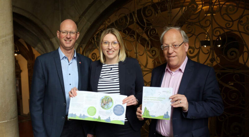 Freuen sich über das neue Lernheft für Grundschulkinder: Thomas Tappe, Bürermeiste der Stadt Halle, Steinhagens Bürgermeisterin Sarah Süß und Oberbürgermeister der Stadt Bielefeld Pit Clausen (von links). Foto: Stadt Bielefeld