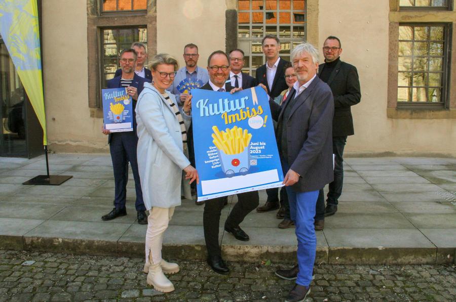 Silvia Herrmann (Organisationsteam des Landesverbandes Lippe, vorn von links), Jörg Düning-Gast (Verbandsvorsteher) und Carsten Hormes (Kulturbüro OWL) sowie (hinten, von links) Kabarettist Ingo Börchers, Frank Meier (Bürgermeister Extertal), Friso Veldink (Bürgermeister Dörentrup), Dirk Scherning (Bereichsleiter Sparkasse Paderborn-Detmold-Höxter), Christoph Vieregge (Kommunikation Sparkasse Lemgo), Petra Claes (Gemeinde Schlangen, Fachbereich Bildung und Organisation) und Marcus Duda (Pressesprecher und Marketingleiter Lippische Landesbrandversicherung) haben den Startschuss zum „Kulturimbiss Lippe 2023“ gegeben. Foto: LVL