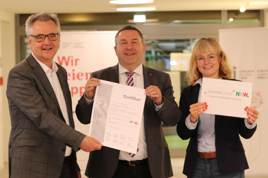 Uwe Gotzeina, Leiter der Kreiswirtschaftsförderung, Landrat Dr. Axel Lehmann und Michaela Hanke, Projektmanagerin der Kreiswirtschaftsförderung, präsentieren das Zertifikat zum Startercenter NRW. (Foto: Kreis Lippe)