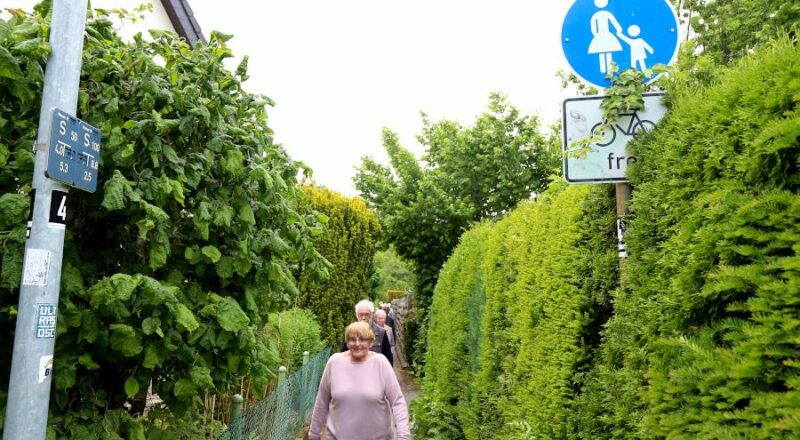 Der Rotdornweg ist innerhalb der Bebauung so schmal, dass die Teilnehmer am Dorfgespräch hintereinander gehen müssen. Foto: Thomas Dohna