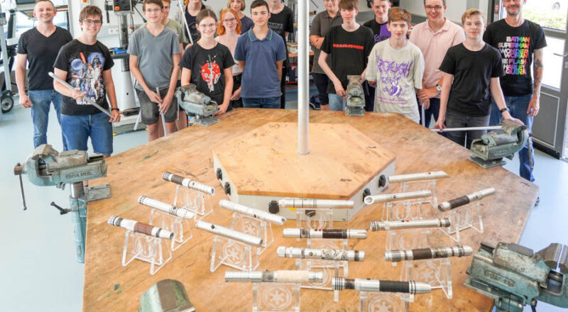 Die Dozenten Erwin Schadt (l.) und Kai Lenski (r.) mit den Teilnehmenden des Lichtschwert Camps 2022 mit ihren fertigen Lichtschwertgriffen. Foto: Lippe Bildung eG