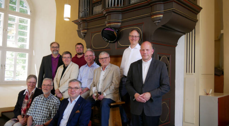 Vor der Klausing-Orgel von 1748 in der Schlosskirche Varenholz. Mit Kirchenführerin Vera Varlemann (Varenholz), Pfarrer Horst-Dieter Mellies (Lüdenhausen), Gerhard Grote (Helpup), Gregor Schwarz (Heilig Geist Lemgo), Diakon Torben Sprenger (Varenholz), Landeskantor Burkhard Geweke, Sven Limberg (Sponsorenvertreter der Lippischen Landesbrand AG), Friedrich Brakemeier (Lippischer Heimatbund), Pfarrer Björn Kruschke (Hiddesen) und Pfarrer Thomas Weßler (Wüsten) (von links). Foto: Lippische Landeskirche