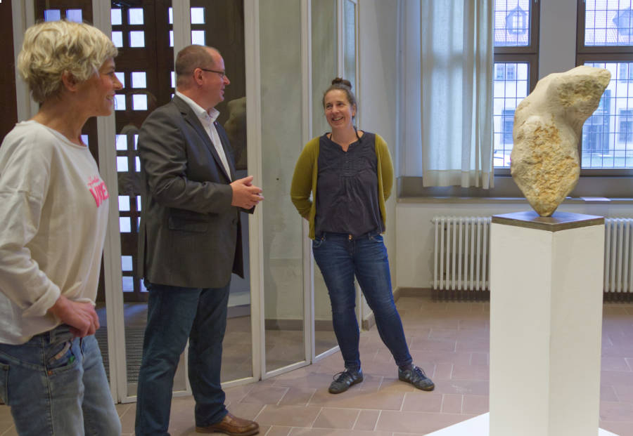 Carolin Engels (rechts) präsentiert Arne Brand (Allg. Vertreter des Verbandsvorsteher) und Vera Scheef (Lippische Kulturagentur) ihre aus Thüster Kalkstein entstandene Skulptur. Foto: LVL