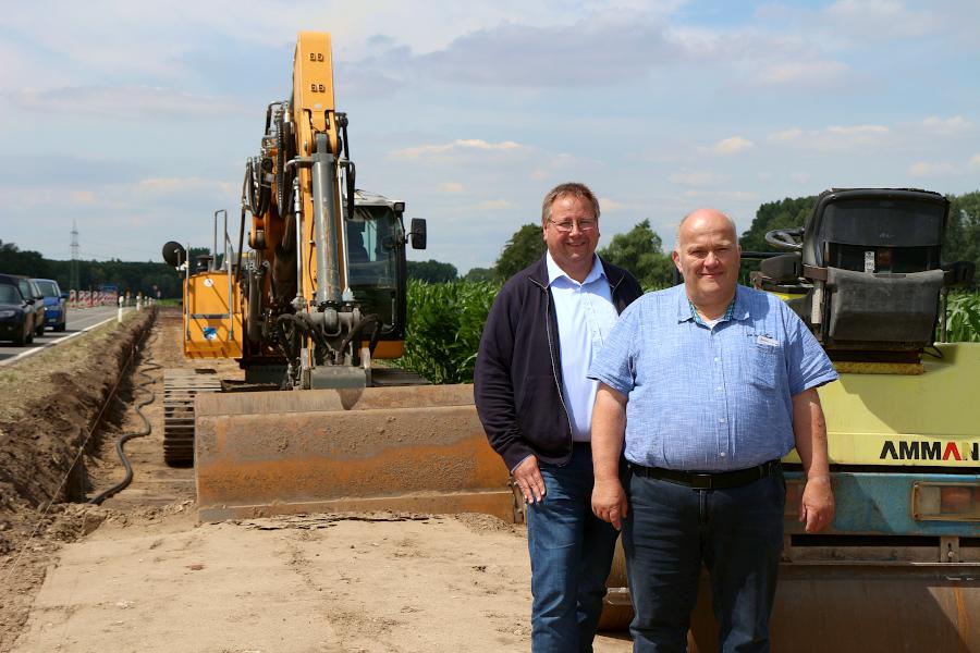 Thomas Jahn, Kreistagsabgeordneter der SPD, und Andreas Brinkmann, Gemeinderatsmitglied in Leopoldshöhe für die SPD, stehen auf der Baustelle für den Bürgerradweg an der Schackenburger Straße. Foto: Thomas Dohna