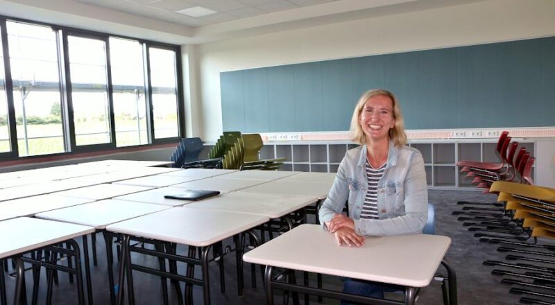 Architektin Peggy Balke sitzt an einem der Einzeltische, mit denen die Klassenräume möbliert sind. Die hintere Seite der Klassenräume ist mit Steckdosen und einer Pinnwand ausgestattet. Im Hintergrund ist eine Pinnwand Foto: Thomas Dohna