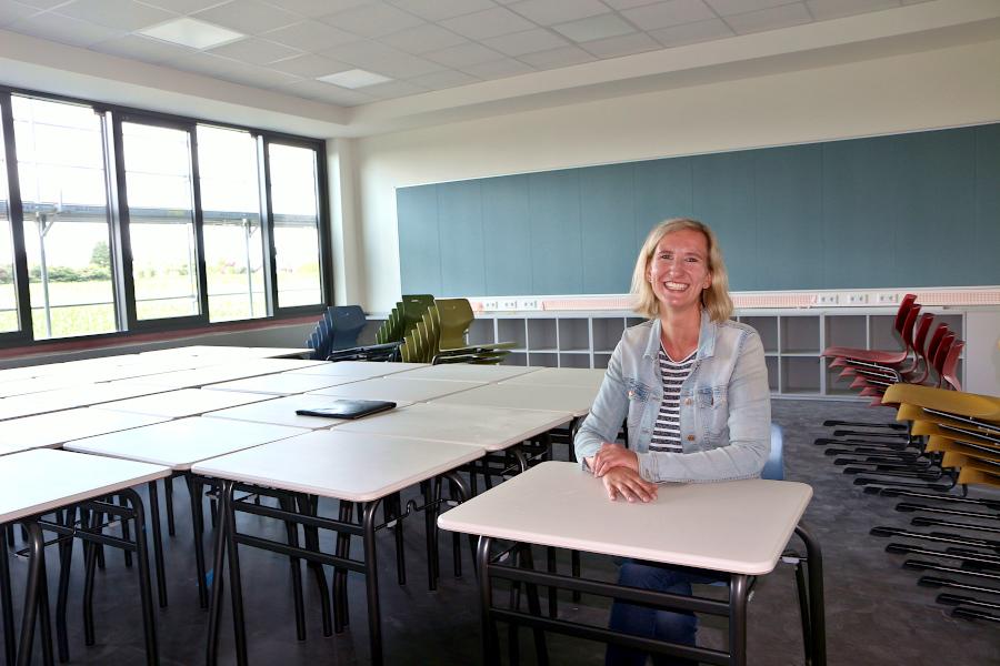 Architektin Peggy Balke sitzt an einem der Einzeltische, mit denen die Klassenräume möbliert sind. Die hintere Seite der Klassenräume ist mit Steckdosen und einer Pinnwand ausgestattet. Im Hintergrund ist eine Pinnwand Foto: Thomas Dohna