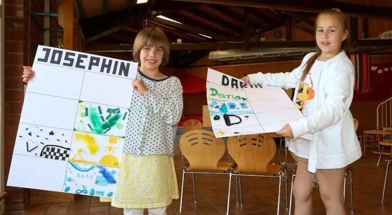 Josephin (links) und Daria zeigen ihre Plakate, auf denen sie ihre Tage bei den Ferienspielen im Leos dokumentieren. Foto: Thomas Dohna