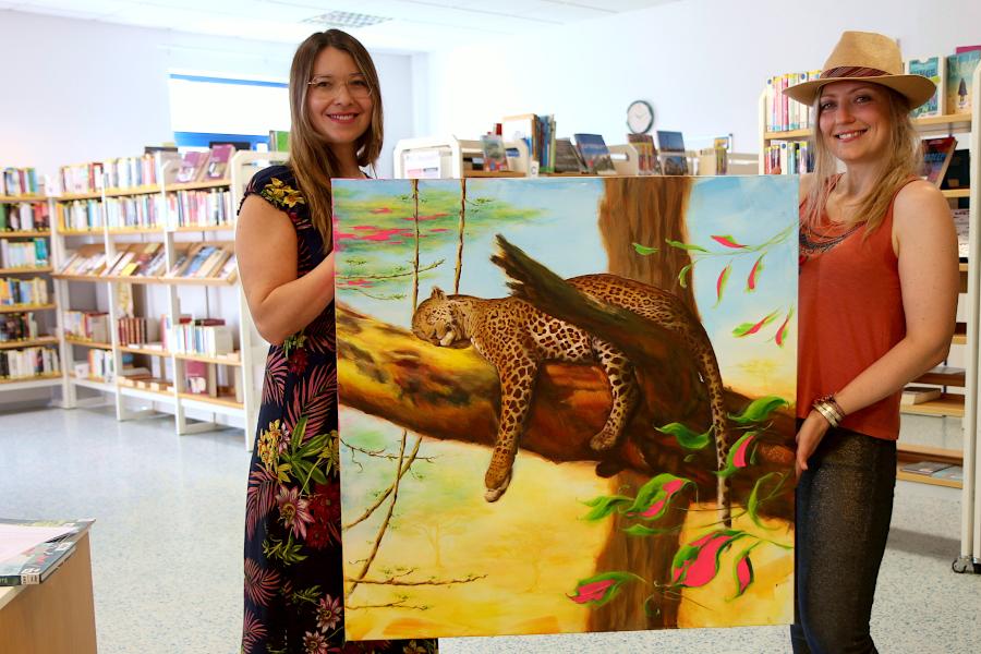 Katharina Harms (links) und Katharina Dyk halten das Bild "Leopard", das Harms von Dyk gekauft hat. Kennengelernt haben die beiden sich über die Gemeindebücherei. Foto: Thomas Dohna