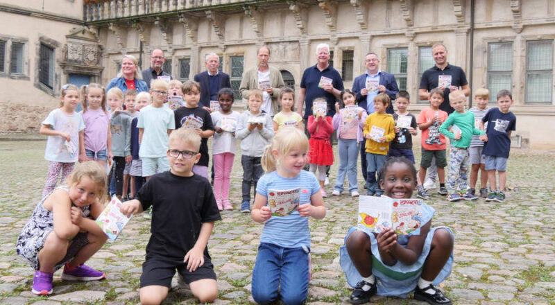 Auf dem Foto freuen sich zusammen mit der 1a der Grundschule am Schloss (v.r.): Jörg Franks, Schulleiter der Grundschule am Schloss, Landrat Dr. Axel Lehmann, Manfred Hütte, Verlagsleiter vom Kurier Verlag, Hermännchen-Zeichner Mark Schäferjohann, Dr. Albert Hüser, Vorsitzender vom Lippischen Heimatbund, Jörg Düning-Gast, Verbandsvorsitzender vom Landesverband Lippe und Klassenlehrerin Alexandra Kehl (Foto: Kreis Lippe)