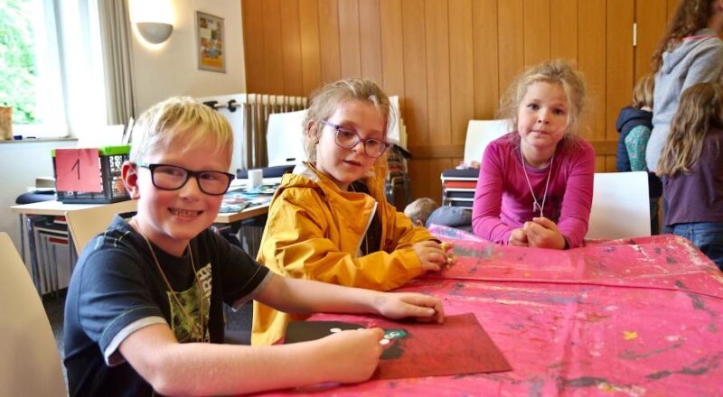 Henri (von links), Nele und Emilia haben Friedenstauben gemalt. Foto: Thomas Dohna