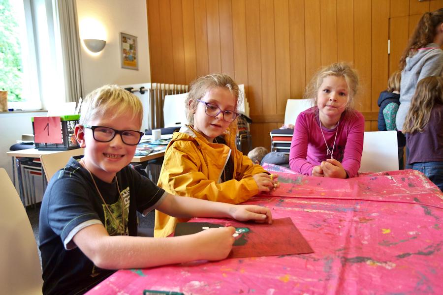 Henri (von links), Nele und Emilia haben Friedenstauben gemalt. Foto: Thomas Dohna