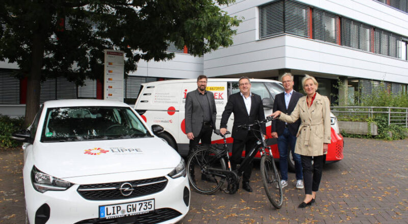 Landrat Dr. Axel Lehmann (zweiter von links); Achim Oberwöhrmeier (links), Geschäftsführer der Kommunalen Verkehrsgesellschaft Lippe (KVG); Thomas Hilker (zweiter von rechts), stellvertretender Leiter des Eigenbetriebs Straßen und Dr. Ute Röder (rechts), Verwaltungsvorständin präsentieren die klimafreundlichen Fahrzeuge des Kreises. Mit E-Dienstwagen und Pedelecs können die Mitarbeitenden des Kreises zu Terminen fahren. Der ID-Buzz dient als Infomobil zur Auskunft über Fahrpläne, Ticketpreise und andere Fragen rund um das Thema ÖPNV in Lippe. Foto: Kreis Lippe