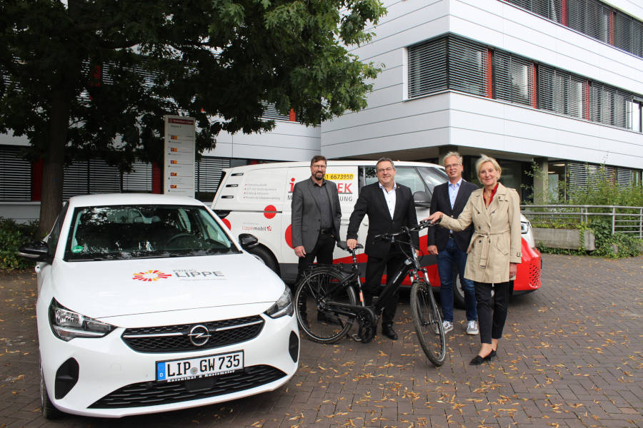 Landrat Dr. Axel Lehmann (zweiter von links); Achim Oberwöhrmeier (links), Geschäftsführer der Kommunalen Verkehrsgesellschaft Lippe (KVG); Thomas Hilker (zweiter von rechts), stellvertretender Leiter des Eigenbetriebs Straßen und Dr. Ute Röder (rechts), Verwaltungsvorständin präsentieren die klimafreundlichen Fahrzeuge des Kreises. Mit E-Dienstwagen und Pedelecs können die Mitarbeitenden des Kreises zu Terminen fahren. Der ID-Buzz dient als Infomobil zur Auskunft über Fahrpläne, Ticketpreise und andere Fragen rund um das Thema ÖPNV in Lippe. Foto: Kreis Lippe