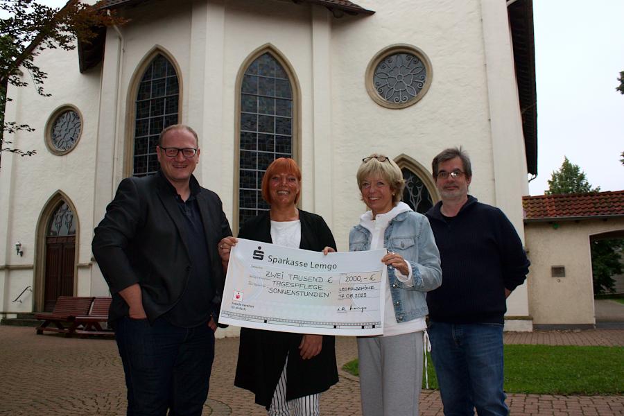 Fabian Adler vom Projektchor, Jaqueline Munder (Leiterin der Tagespflege Sonnenstunden), Chorsprecherin Helga Kamp und Chorleiter Dirk Martin bei der Übergabe des symbolischen Schecks. Foto: Thomas Dohna