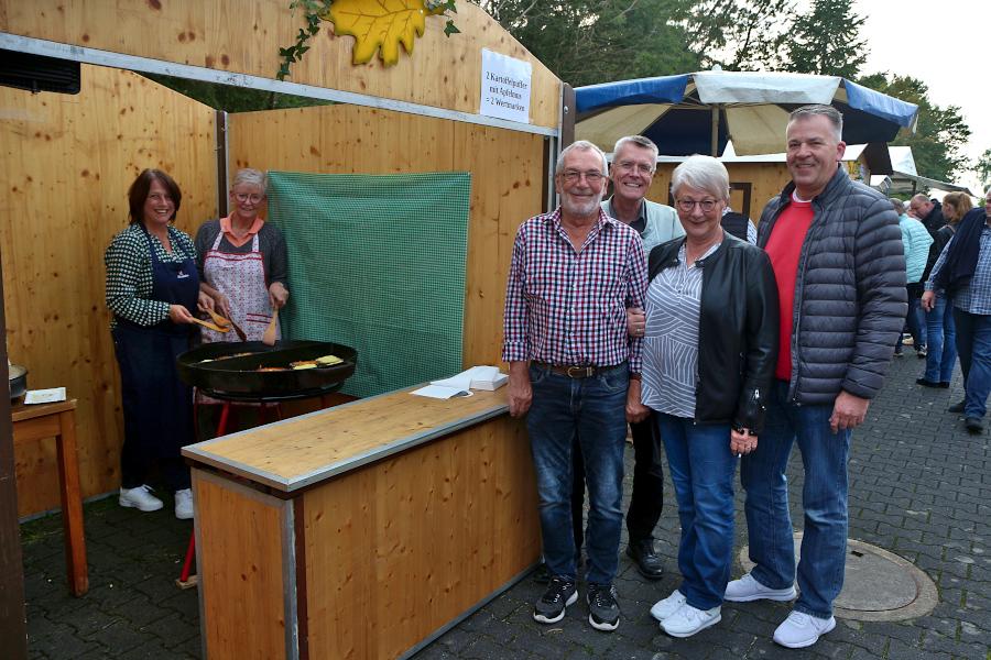 Manuela Kunze und Judith Leymann backen beim Kartoffelfest des Schützenfestes Nienhagen Kartoffelpuffer. Das Königspaar Klaus (links) und Annette Bäcker (Zweite von rechts) sowie der Vorsitzende des Vereins Ralf Schulz-Henze (Zweiter von links) und der Oberst Michael Genett schauen vorbei. Foto: Thomas Dohna