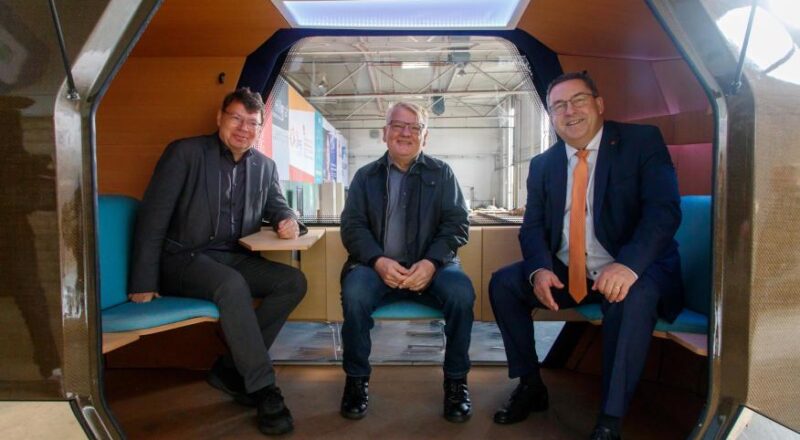 Horst Fischer, Geschäftsführer der IGA Metropole Ruhr 2027, Norbert Schilff, Bürgermeister der Stadt Dortmund und erster Stellvertreter des Oberbürgermeisters, und Landrat Axel Lehmann sitzen probeweise in einem Monocab, das 2027 in Dortmund fahren soll. Foto: IGA / Peter Wehowsky