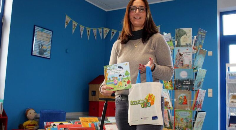 Büchereileiterin Kerstin Koppmann zeigt die Tüten, die Kinder und Eltern zum Lesestart in der Gemeindebücherei bekommen können. Foto: Thomas Dohna