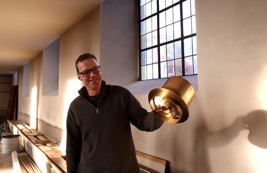 Küster Eckardt Wedemann hält eine der ausgebauten Deckenlampen in der Hand. Foto: Edeltraud Dombert