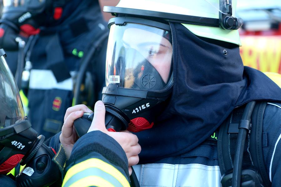 Eine Kameradin schraubt an Julie Schützes Maske den Lungenautomaten an. Foto: Thomas Dohna