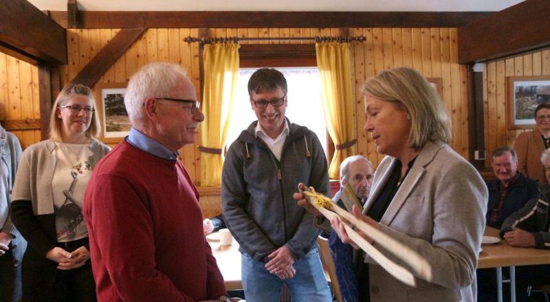 Die Leader-Regionalmanagerin Susanne Weißhaupt überreicht dem Vorsitzenden des Heimatvereins Helmut Depping zur Einweihung des neuen Anbaus am Heimathof eine Grillzange. Bürgermeister Martin Hoffmann schaut zu. Foto: Thomas Dohna