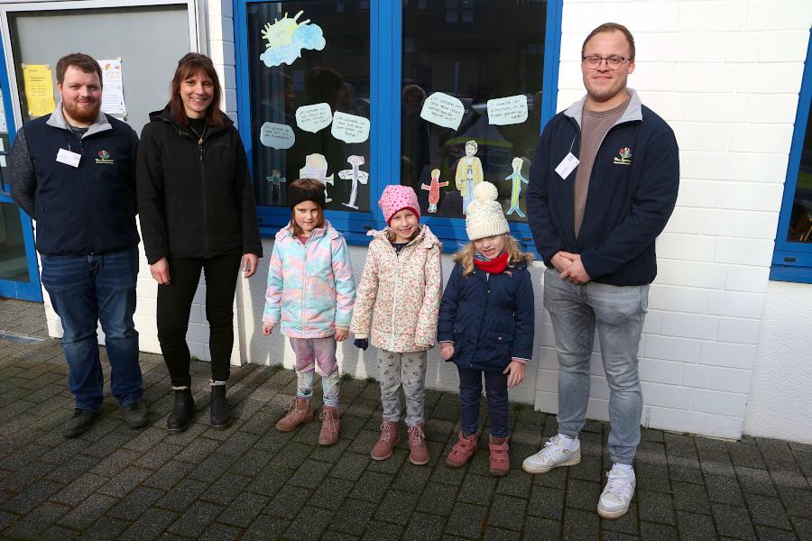 Jonas Droste (von links) von der Kita Spatzennest, Mutter Sarah Landermann, diue Kinder Svea, Liske und Julia sowie Yannik Bilke (Kita Spatzennest) stehen vor dem Fenster, das Kinder der Kita Spazennest gestaltet haben. Foto: Thomas Dohna